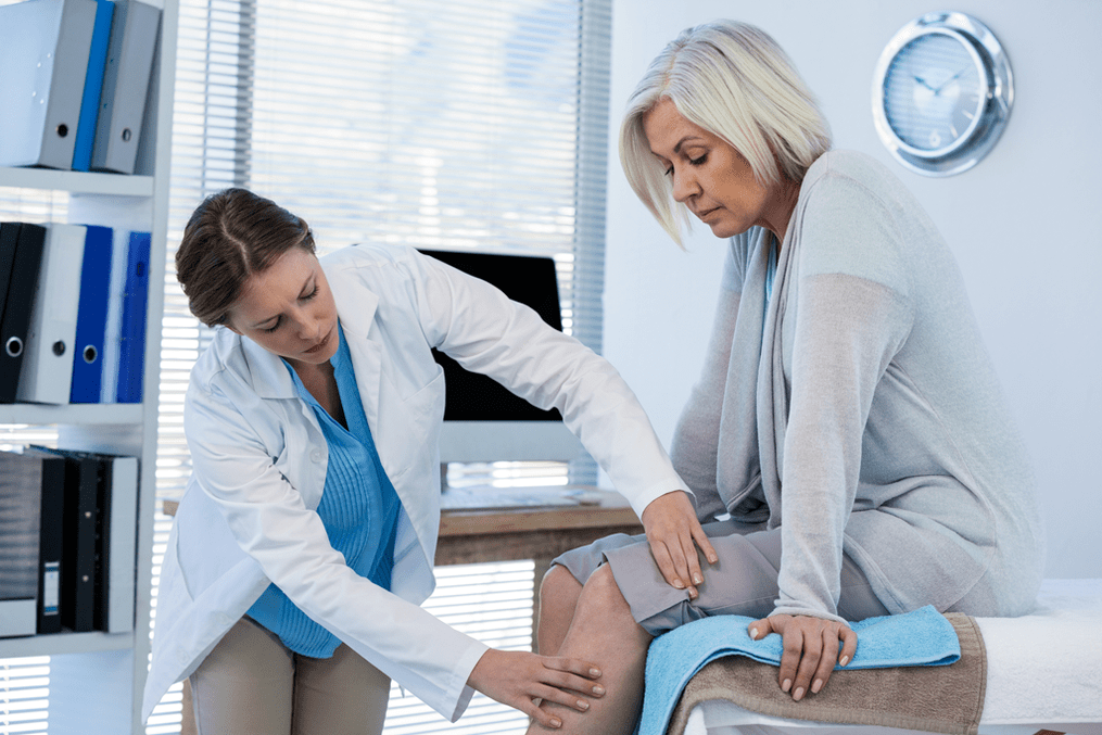 Un paciente con osteoartritis que requiere tratamiento siendo examinado por un médico